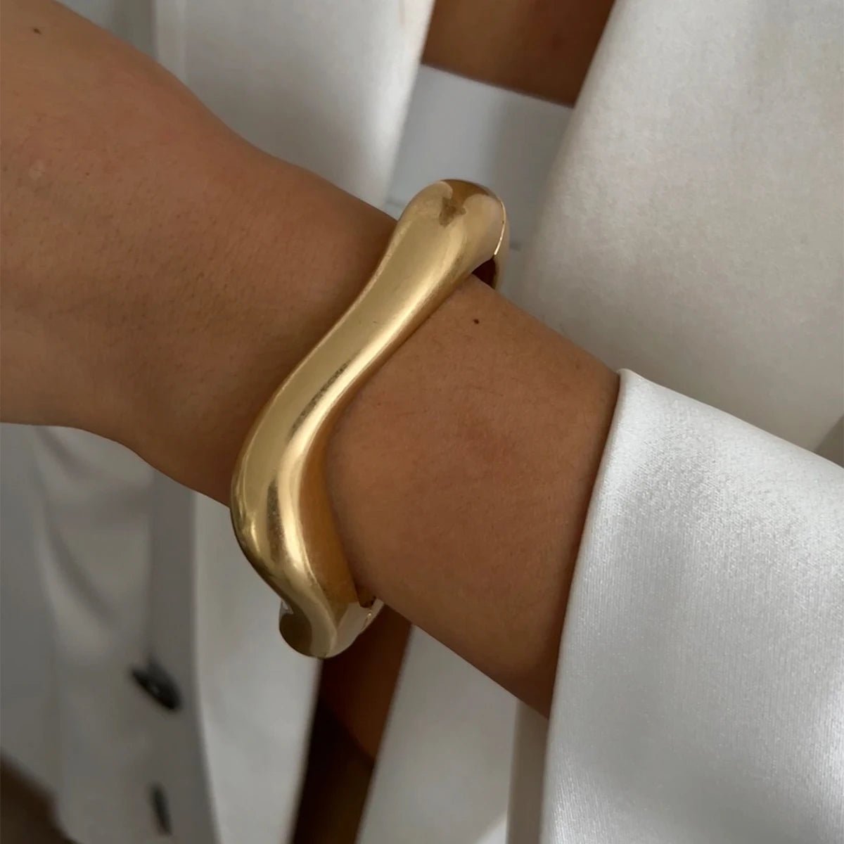une femme porte un bracelet tendance 2025 dore