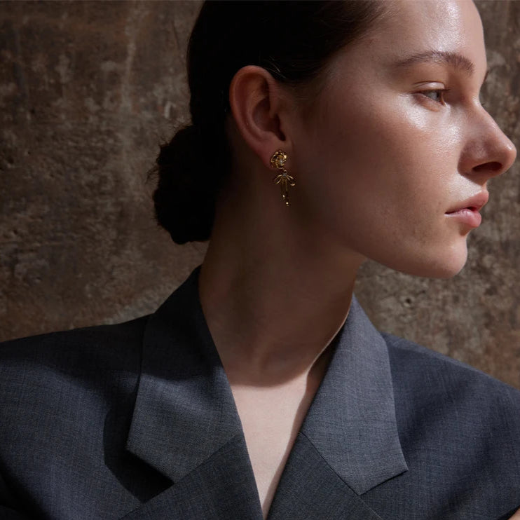 femme porte boucle d'oreille noeud acier inoxydable doré